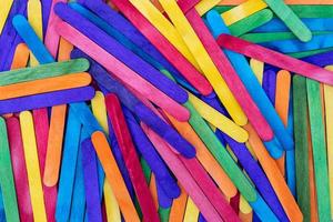 Popsicle sticks of various colors are stacked on top of each other. photo