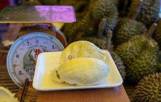 Durian slices in a foam pad near the scales. photo