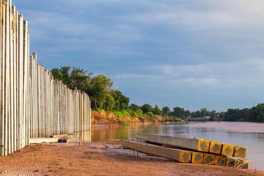 Many views of concrete columns near the river shore. photo