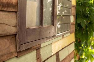 Side windows with wooden walls near the old leaves. photo