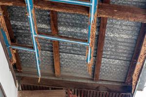 A decayed wood structure under the zinc roof of a house. photo