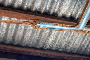 Weathered wood from termites under the zinc roof of the house. photo