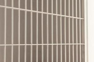 White steel bars inside a prison cell. photo