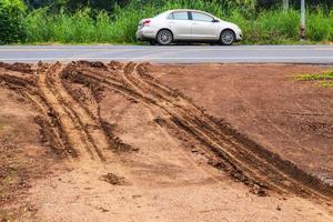 Wheel tracks on a dirt road near the asphalt. photo