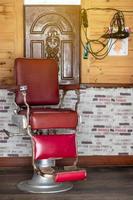 viejo peluquero de silla roja en una barbería. foto