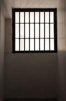rejillas de ventana dentro de la antigua prisión en alguna parte. foto