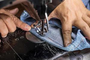 Female hand and denim with old sewing machine. photo