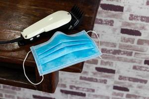 Clippers and a mask is placed on a wooden table. photo