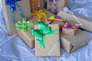 Many gift boxes tied with beautiful bows on gray canvas. photo