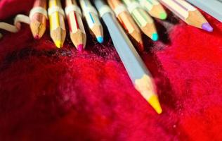 el enfoque selectivo se acerca a los bolígrafos de color sobre una superficie de fieltro rojo. foto