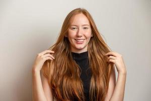 Portrait of beautiful cheerful redhead girl smiling laughing looking at camera over white background. photo