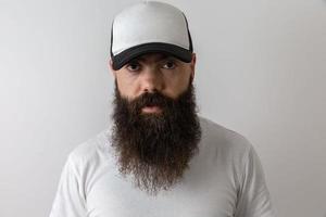 Hipster handsome male model with beard. Baseball cap with space for your logo photo