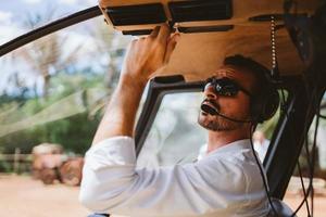 Male mechanic or pilot examining helicopter. Pre flight inspection at the helipad photo