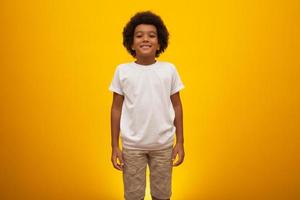 niño afroamericano con cabello de poder negro sobre fondo amarillo. niño negro sonriente con un cabello de poder negro. chico negro con un cabello de poder negro. ascendencia africana. foto