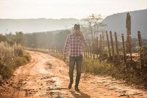 Farmer or country man using a smartphone on the farm. Internet 4G farmer. Social networks, online consultations. photo