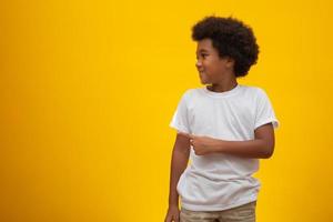 African American boy with black power hair on yellow background. Smiling black kid with a black power hair. Black boy with a black power hair. African descent. photo