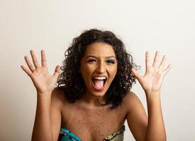 Image of excited screaming young woman standing isolated over grey background. Looking camera. photo