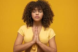 Smiling peaceful young woman practicing yoga and meditation. Calm woman making Namaste gesture and looking at camera. Yoga concept. Gratitude. photo