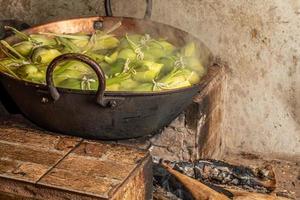 Brazilian sweet corn dessert called Pamonha. Festa Junina Party. Brazilian culture. Cooking in the pan. Wood burning stove. photo