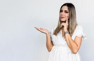 A young Latin girl points to the sides. Advertisement and presentation concept. photo