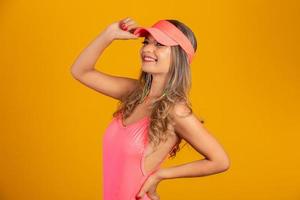 Attractive girl in a pink bikini, hat, emotionally opened mouth on a bright yellow background with a perfect body. Isolated. Studio shot. photo
