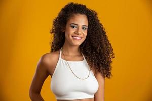 hermosa chica afroamericana con un peinado afro sonriendo. retrato de belleza de mujer afroamericana con peinado afro y maquillaje glamoroso. joven brasileña. foto