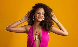 hermosa chica afroamericana con un peinado afro sonriendo. retrato de belleza de mujer afroamericana con peinado afro y maquillaje glamoroso. joven brasileña. foto