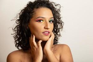 chica modelo de moda de belleza con cabello rizado y maquillaje colorido. mujer afro sonriendo a la cámara foto