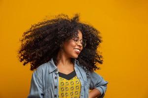 Beauty portrait of african american woman with afro hairstyle and glamour makeup. Brazilian woman. Mixed race. Curly hair. Hair style. Yellow background. photo