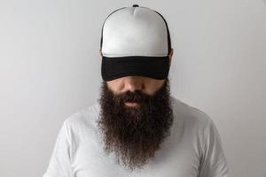Hipster handsome male model with beard. Baseball cap with space for your logo photo