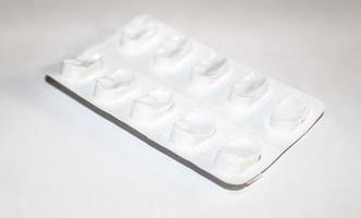 concepto de farmacia farmacia. paquetes de pastillas blancas envasadas en ampollas con espacio de copia aislado en un fondo blanco. centrarse en primer plano, bokeh suave. foto