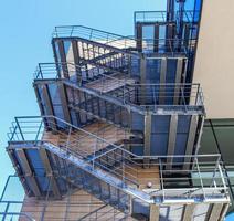 Big metallic stairs at a modern architecture building against a blue sky.