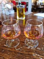 Two glasses of amaretto with soft background on a wooden table. photo