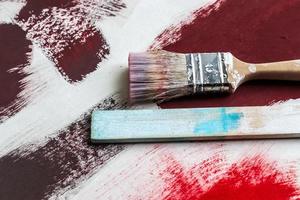 Concept of a paintbrush on a piece of paper with brush strokes in red and brown photo