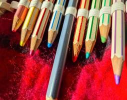 Selective focus close up at color pens lying on a red felt surface. photo