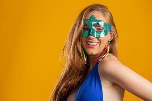 hermosa mujer vestida para la noche de carnaval. mujer sonriente lista para disfrutar del carnaval con una máscara colorida. foto