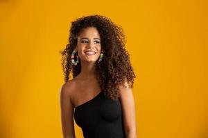Beautiful african american girl with an afro hairstyle smiling. Beauty portrait of african american woman with afro hairstyle and glamour makeup. Brazilian young woman. photo