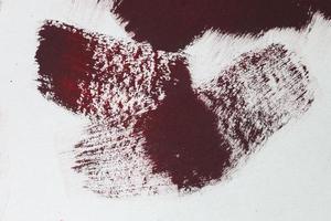 Concept of a paintbrush on a piece of paper with brush strokes in red and brown photo