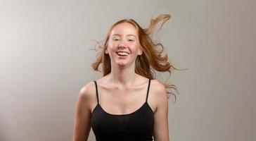 Portrait of beautiful cheerful redhead girl smiling laughing looking at camera over white background. photo