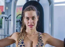 Girl training pectoral in gym apparatus photo