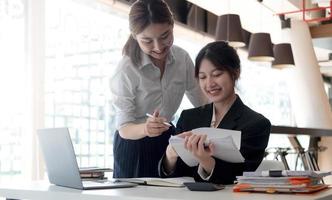 Two young asia business woman working together in office space photo