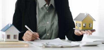 corredor de bienes raíces que presenta al cliente la decisión de firmar un contrato de bienes raíces con una solicitud de hipoteca aprobada, comprar una oferta de préstamo hipotecario y un seguro de vivienda.