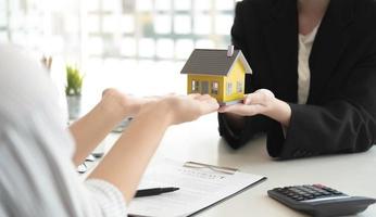 representante de ventas ofrece contrato de compra de casa para comprar una casa o apartamento o discutir sobre préstamos y tasas de interés foto