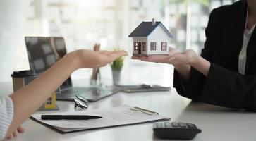 representante de ventas ofrece contrato de compra de casa para comprar una casa o apartamento o discutir sobre préstamos y tasas de interés foto