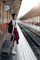 Summer, Travel, Vacation, Relax, A smiling female tourist looks at the train station for a summer vacation, travel concept photo