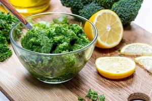 Green sauce with fresh herbs with vegetables in a glass bowl closeup. The concept of healthy eating