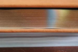 Side view. Close up view at a thick old book with golden pages. photo