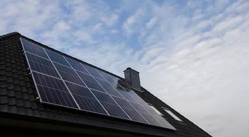 Solar panels producing clean energy on a roof of a residential house photo