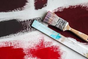 Concept of a paintbrush on a piece of paper with brush strokes in red and brown photo