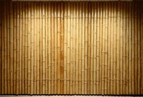 background and texture of decorative yellow bamboo wood on finishing wall surface. photo